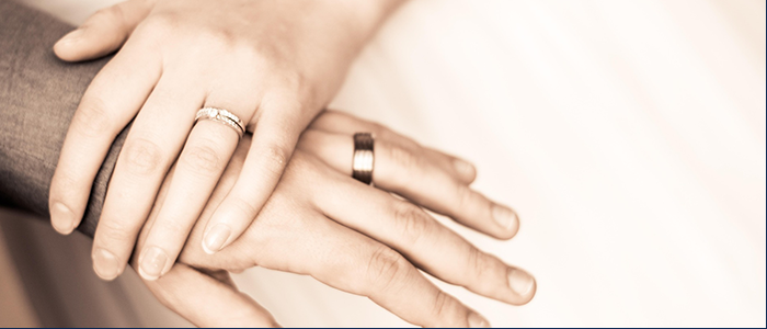 結婚指輪を付けた男女の手先